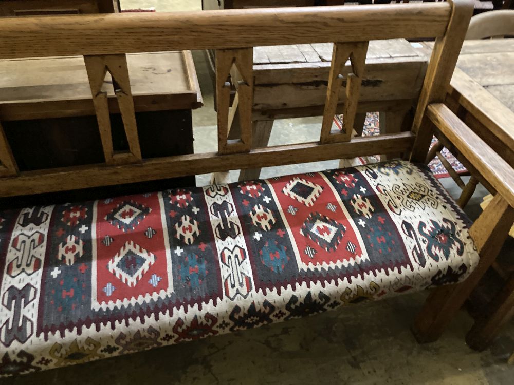 A 19th century Continental oak bench settle, with kelim upholstered seat, width 200cm depth 48cm height 104cm